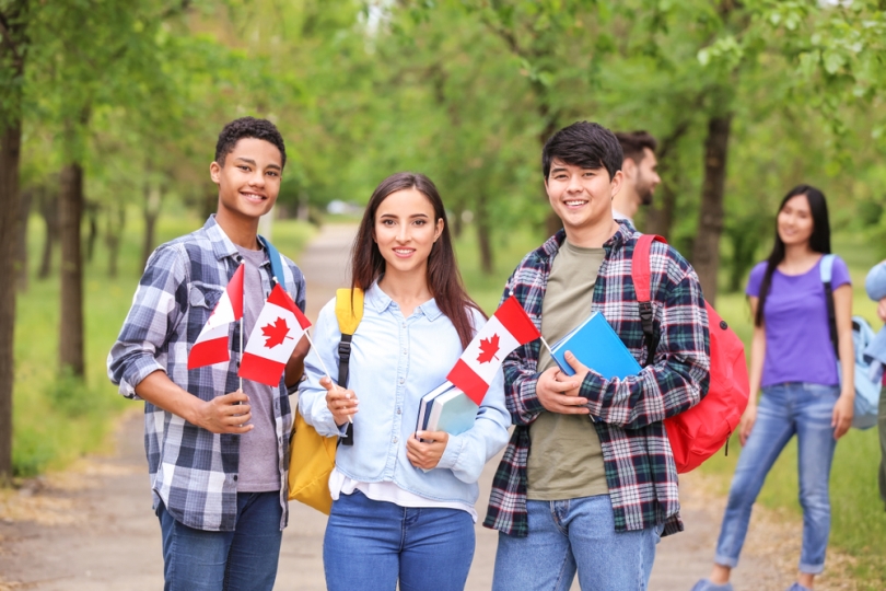 A group of students on campus waving Canadian flags.